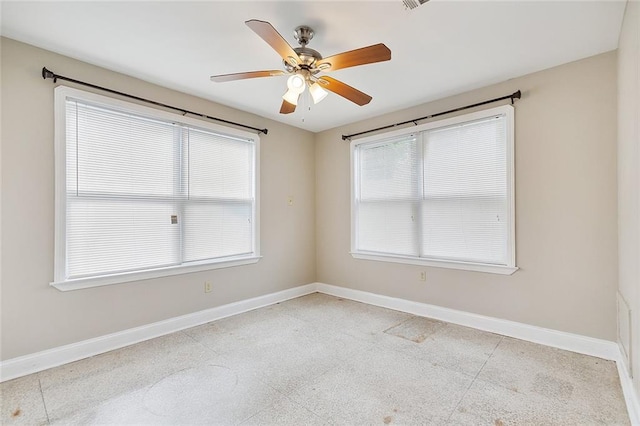 spare room with baseboards and a ceiling fan