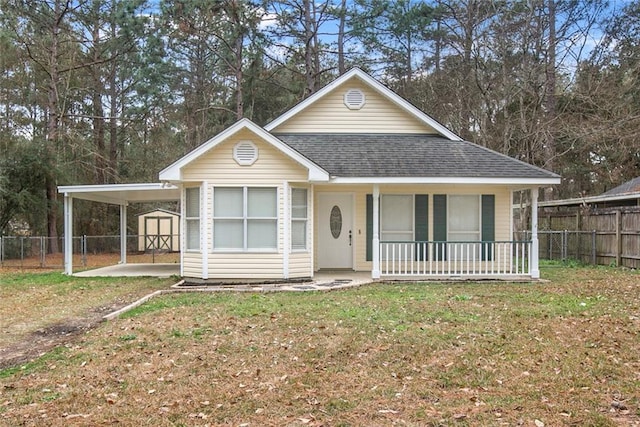 view of front facade with a porch, a shed, and a front yard