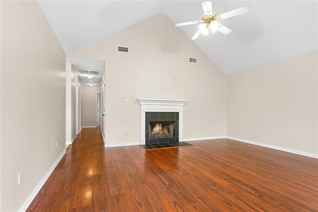 unfurnished living room with ceiling fan, high vaulted ceiling, dark hardwood / wood-style floors, and a tiled fireplace