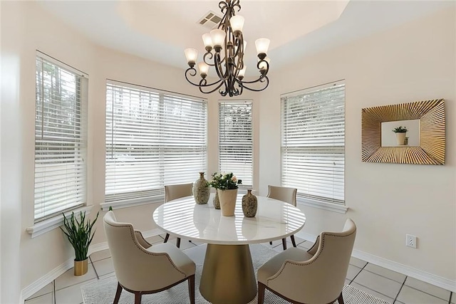 dining area featuring light tile patterned floors and an inviting chandelier