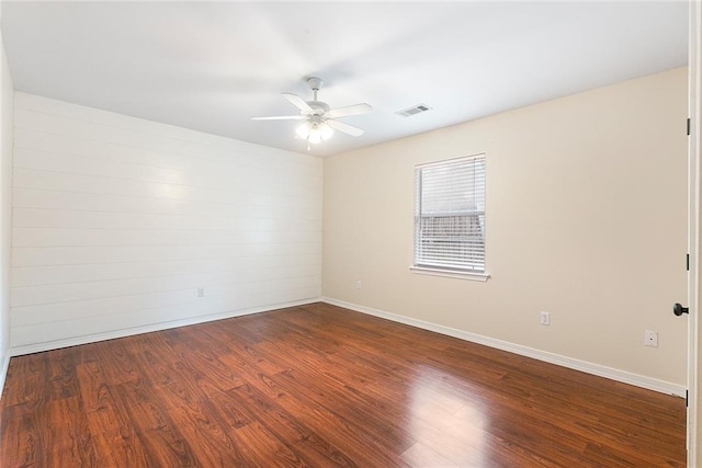 empty room featuring ceiling fan and dark wood-type flooring