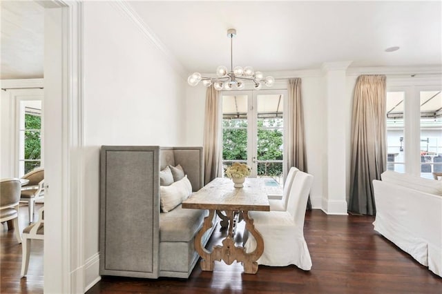 dining area featuring a notable chandelier, ornamental molding, dark hardwood / wood-style floors, and french doors