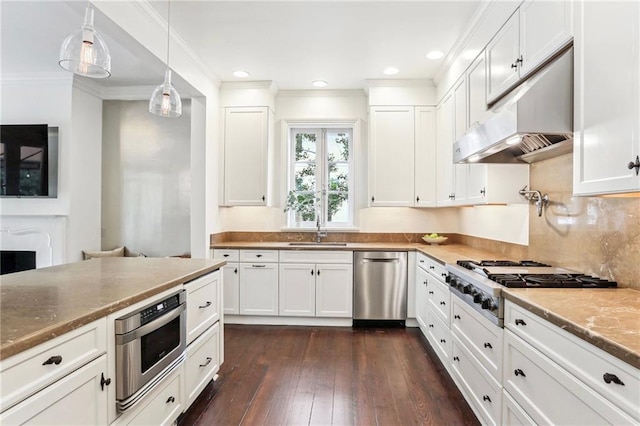 kitchen with appliances with stainless steel finishes, decorative light fixtures, and white cabinets