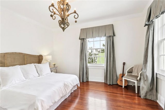 bedroom with dark hardwood / wood-style flooring, a notable chandelier, and ornamental molding