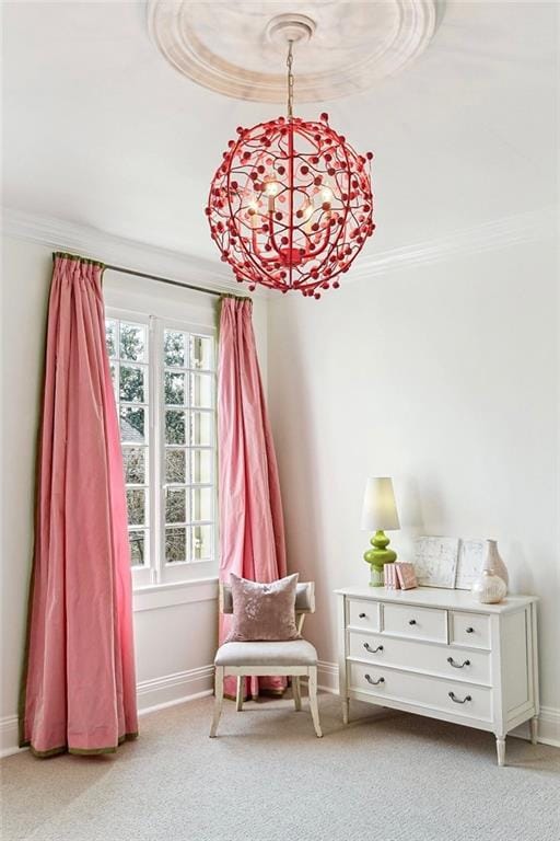 sitting room with ornamental molding, light colored carpet, and an inviting chandelier