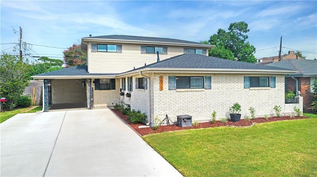 view of front of house featuring driveway, brick siding, and a front yard