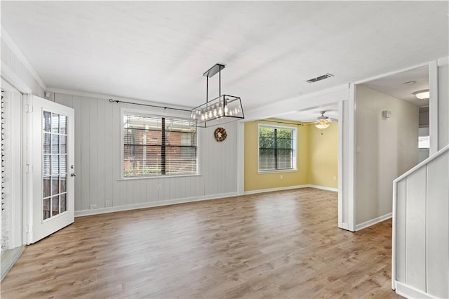 unfurnished dining area featuring light wood-type flooring, ceiling fan, visible vents, and baseboards