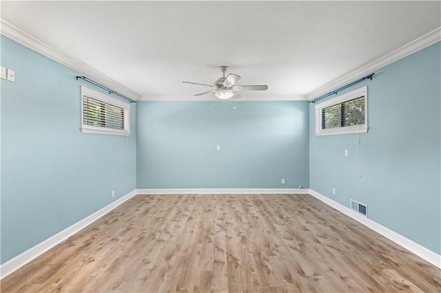 spare room featuring baseboards, plenty of natural light, visible vents, and crown molding