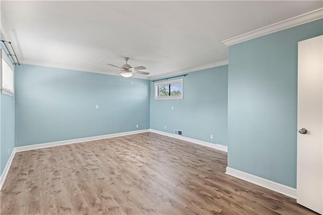 unfurnished room with visible vents, baseboards, a ceiling fan, ornamental molding, and wood finished floors