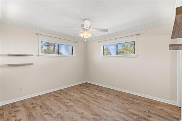 spare room with ornamental molding, a wealth of natural light, and baseboards