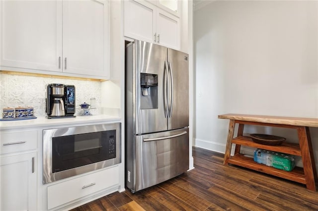 kitchen featuring built in microwave, white cabinetry, stainless steel fridge, and backsplash