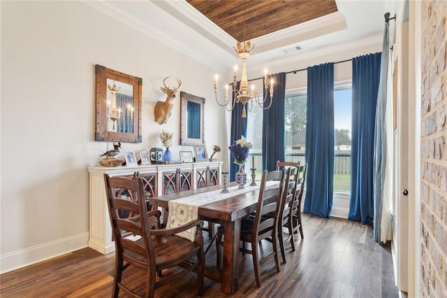 dining room with a raised ceiling, crown molding, dark hardwood / wood-style floors, and a chandelier