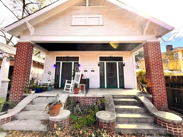 back of property featuring covered porch