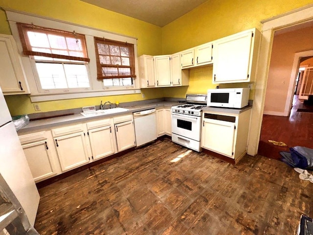 kitchen featuring white appliances, sink, and white cabinets