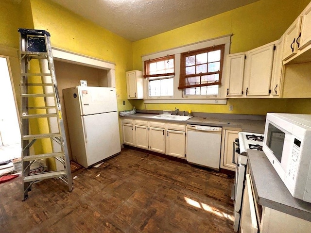 kitchen featuring sink, a textured ceiling, white cabinets, and white appliances