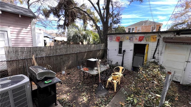 view of yard with central AC unit and an outbuilding