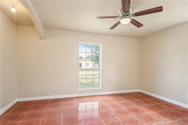 tiled spare room featuring ceiling fan