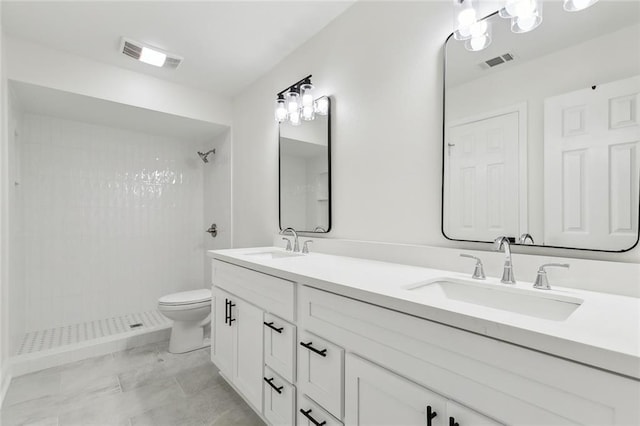 bathroom with vanity, toilet, and a tile shower