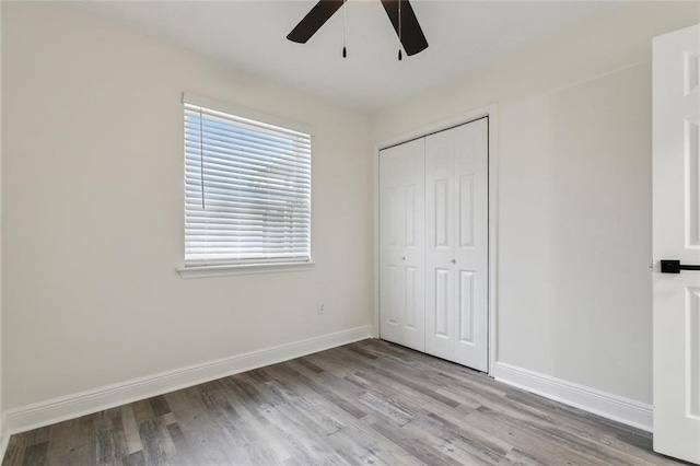 unfurnished bedroom featuring light hardwood / wood-style flooring, a closet, and ceiling fan