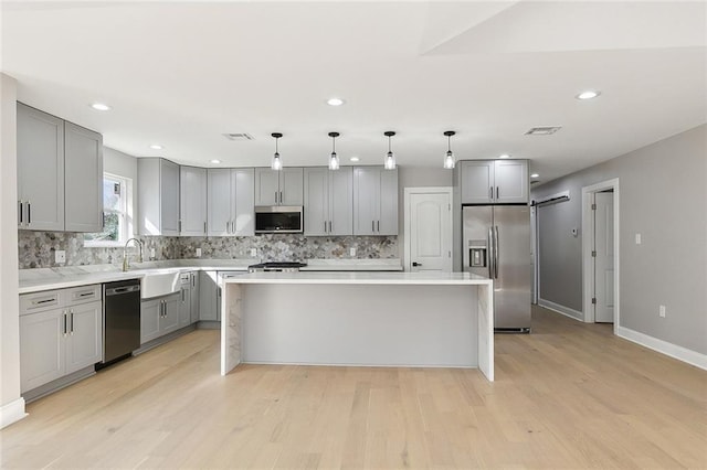 kitchen featuring pendant lighting, tasteful backsplash, stainless steel appliances, and a kitchen island