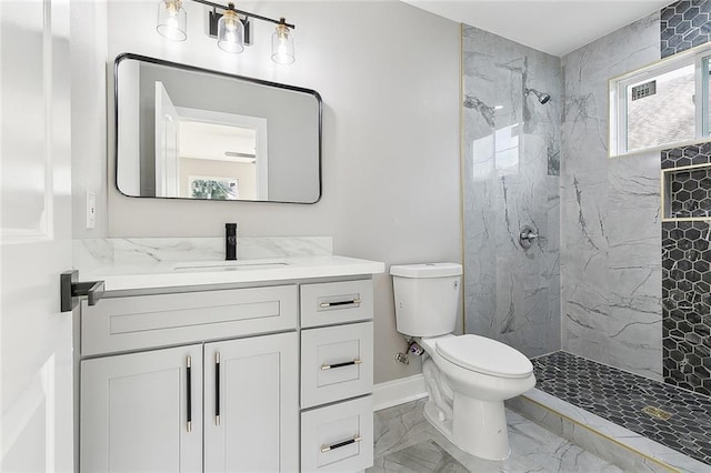 bathroom featuring vanity, toilet, and a tile shower