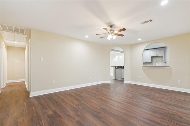 unfurnished living room featuring ceiling fan, dark hardwood / wood-style flooring, and sink