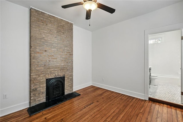 unfurnished living room featuring a stone fireplace, wood-type flooring, and ceiling fan