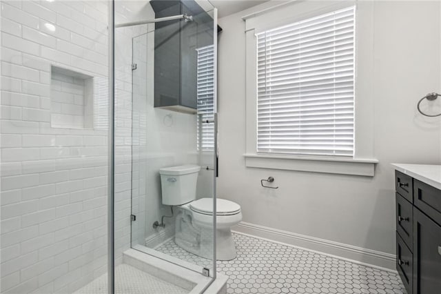 bathroom with vanity, tile patterned flooring, toilet, and walk in shower