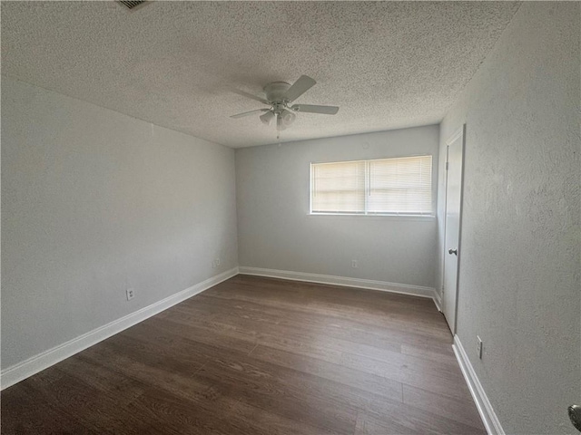 spare room featuring dark hardwood / wood-style flooring, a textured ceiling, and ceiling fan