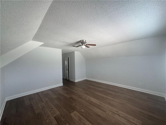 additional living space with ceiling fan, vaulted ceiling, dark hardwood / wood-style floors, and a textured ceiling