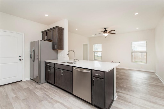 kitchen with dark brown cabinetry, sink, a wealth of natural light, and appliances with stainless steel finishes