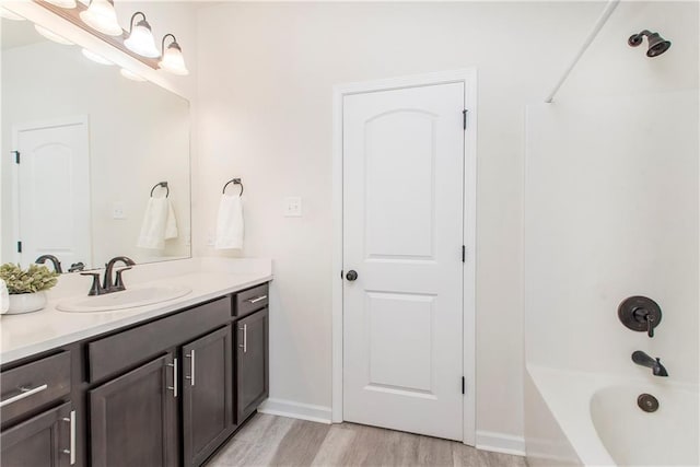 bathroom featuring vanity, hardwood / wood-style floors, and  shower combination