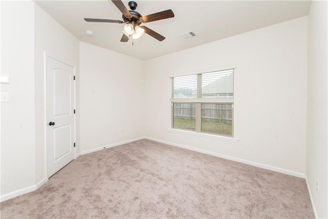 carpeted spare room featuring ceiling fan