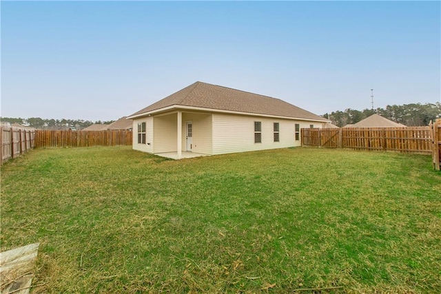 rear view of property featuring a yard and a patio area