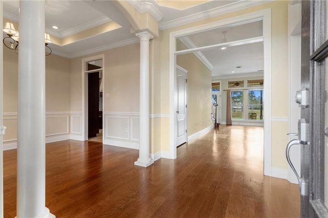 hall with hardwood / wood-style floors, crown molding, and decorative columns