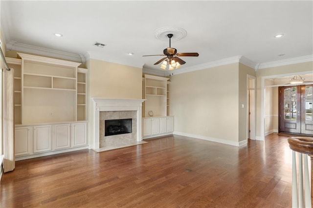 unfurnished living room featuring hardwood / wood-style flooring, ceiling fan, a high end fireplace, and crown molding