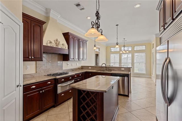 kitchen featuring pendant lighting, sink, stainless steel appliances, custom range hood, and kitchen peninsula