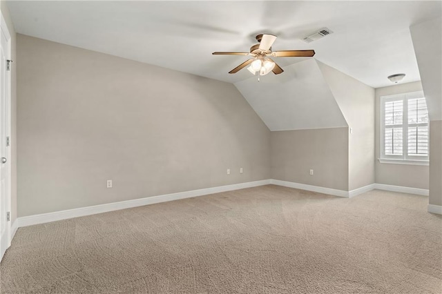 additional living space with vaulted ceiling, light colored carpet, and ceiling fan