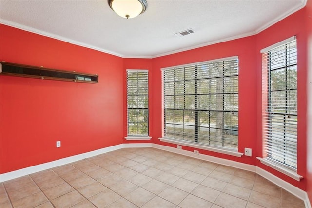 spare room with tile patterned flooring, ornamental molding, and a textured ceiling