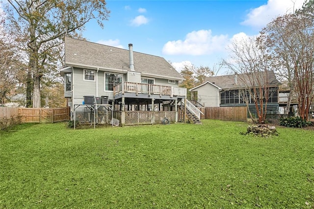 rear view of property with a wooden deck and a yard