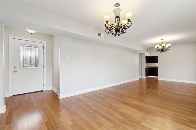 entryway featuring hardwood / wood-style flooring and an inviting chandelier