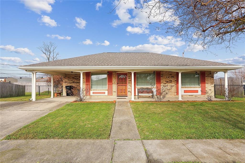 view of front facade featuring a carport, a porch, and a front lawn