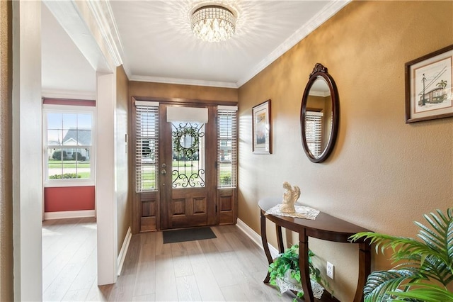 entryway featuring ornamental molding, an inviting chandelier, and light hardwood / wood-style floors