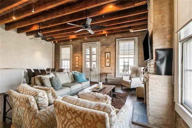 living room with beamed ceiling, ceiling fan, brick wall, and dark hardwood / wood-style flooring