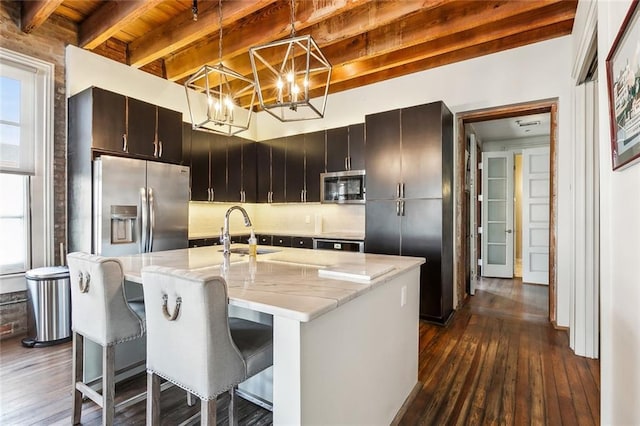 kitchen with appliances with stainless steel finishes, dark hardwood / wood-style floors, pendant lighting, beamed ceiling, and sink