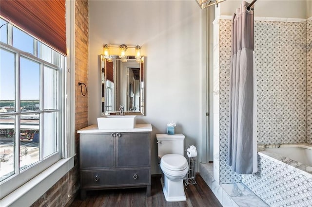 full bathroom featuring wood-type flooring, toilet, vanity, and shower / bath combo with shower curtain