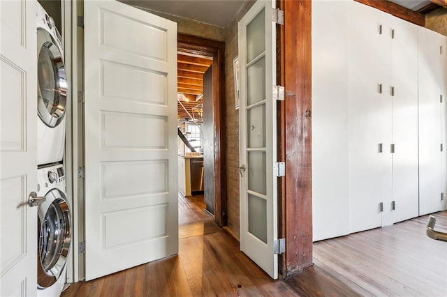 washroom with stacked washer / dryer and hardwood / wood-style floors