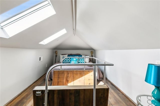 bedroom featuring dark hardwood / wood-style floors and vaulted ceiling with skylight