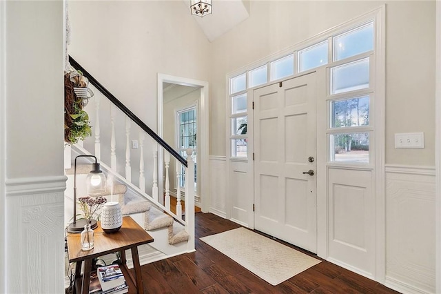 foyer entrance featuring a high ceiling, stairway, and dark wood finished floors