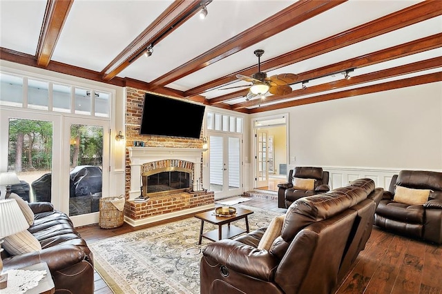 living area with beamed ceiling, ceiling fan, french doors, and wood-type flooring